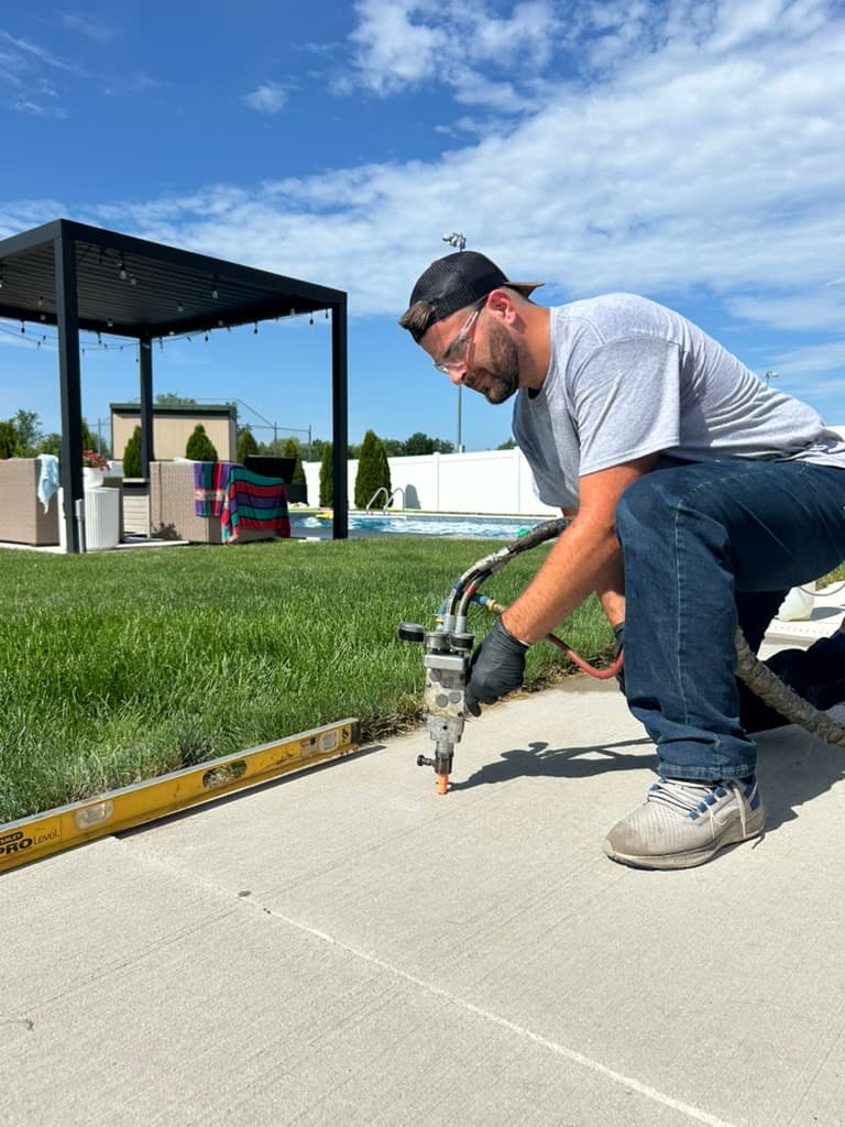 A DD Concrete Leveling technician injecting polyurethane foam to raise a concrete slab